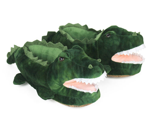 Pair of plush alligator slippers with green scaly textured plush, felt spines, tails, felt teeth, and four legs.
