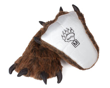 Load image into Gallery viewer, Pair of brown furry grizzly bear paw slippers with black claws, one is resting on a white background and one is turned upwards to show the sole which is white fabric with grippy dots, and it says &quot;Norty M&quot;
